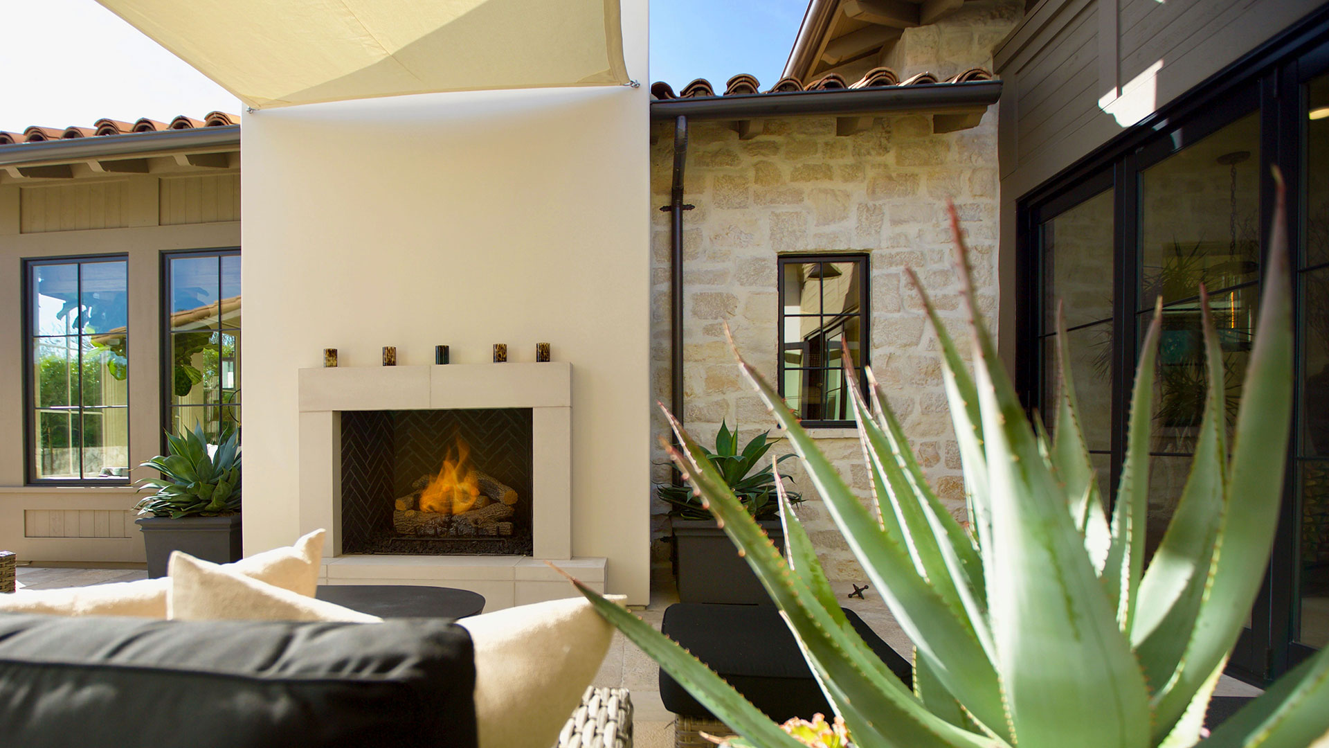 outdoor entertainment area with fireplace honey buff rubble thin veneer installed on wall