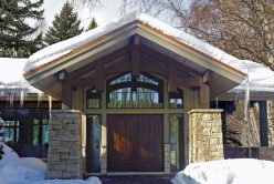 snow covered front of home with Regent Buff rubble natural stone thin veneer installed on exterior walls