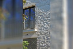 Regent Buff custom architectural cut stone installed on exterior of home with Nadia Pillowed Ledge thin veneer installed on exterior walls