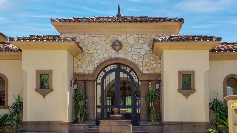 front of home with Montgomery gold rubble tumbled custom profile natural stone thin veneer installed on exterior of home.