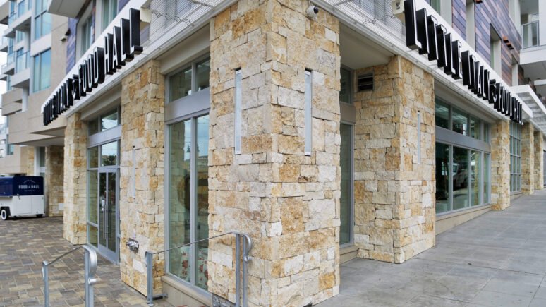 Montgomery Gold Traditional natural stone thin veneer installed on exterior wall of commercial business.